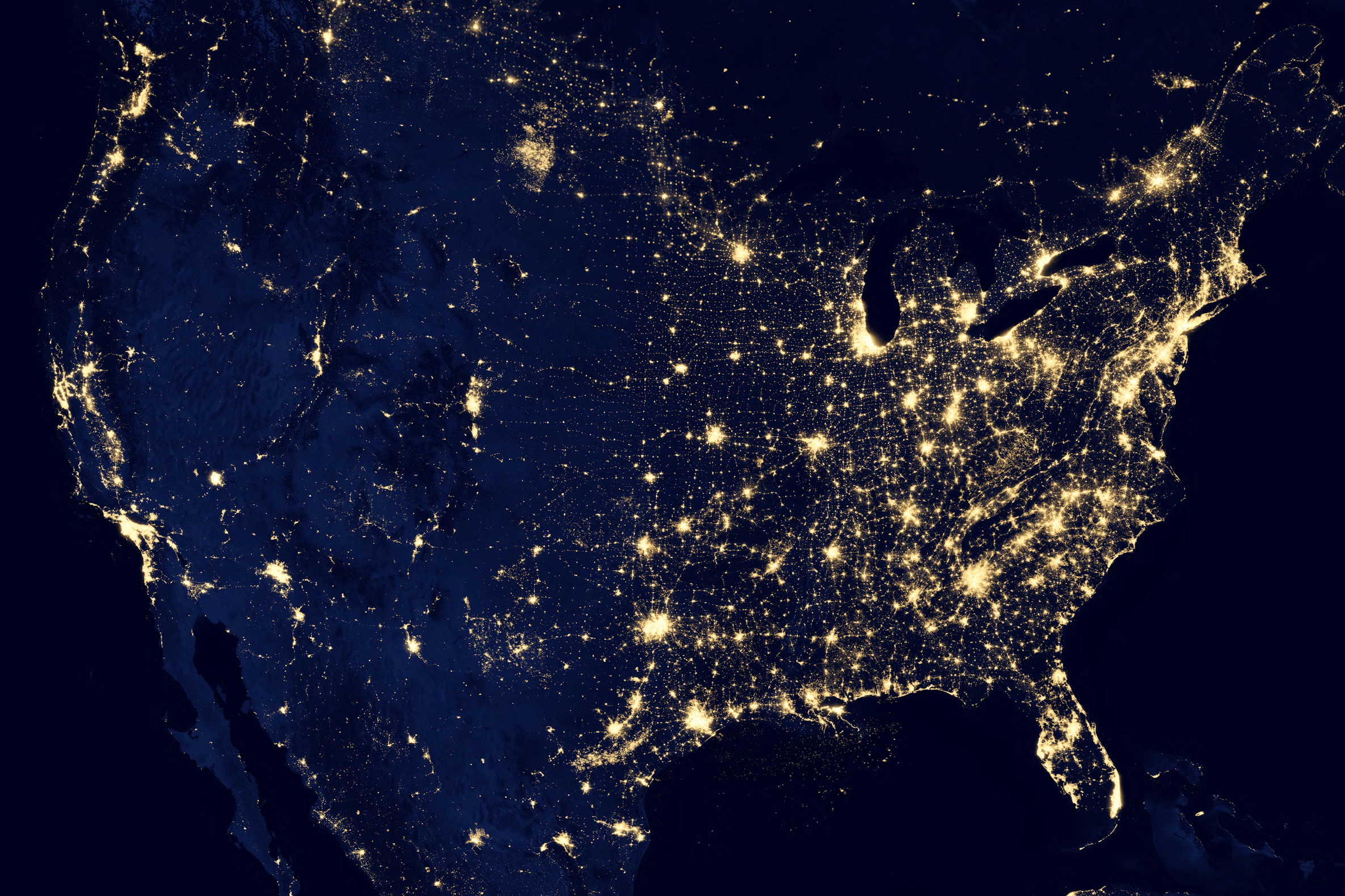 Earth from space at night, illuminated by city lights, symbolizing global energy and security needs
